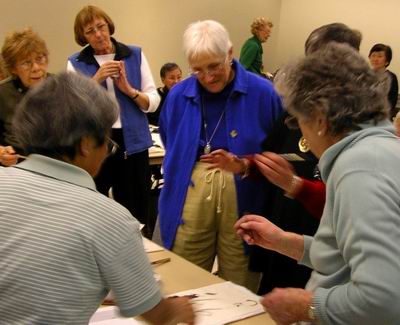 Roslyn discusses painting with several workshop participants